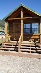 a wooden cabin with a porch and stairs in front at Fantastic Cabin with Fire Pit Close to West Yellowstone, Montana in Lakeview