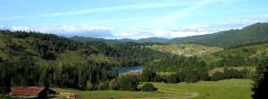 a view of a mountain with a house and a river at Secluded Cabin Ideal for a Romantic Getaway in the Umpqua River Valley of Oregon in Elkton