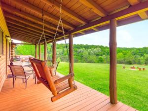 a porch with chairs and a porch swing at Gorgeous and Spacious Cabin Rental for a Group Vacation near Hocking Hills State Park, Ohio in Cedar Grove +32 photos