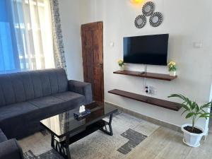a living room with a couch and a flat screen tv at JO Apartment in Malindi