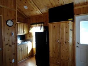 a kitchen with a refrigerator and a clock on the wall at Simple Weekend Getaway near the Black Hills Region of South Dakota in Sundance +1 photo