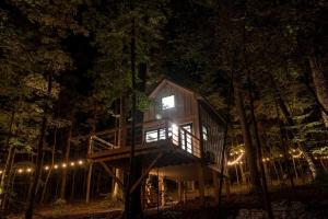 a tree house in the woods at night at Breathtaking Treehouse with Barbecue and Hot-tub in Scottsboro, Alabama in Grant