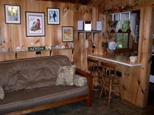 un soggiorno con un divano e un bancone con un bar di Cozy Cottage Rental with Lovely Beach Views on Halfmoon Lake, New Hampshire a New Durham Altre 7 foto