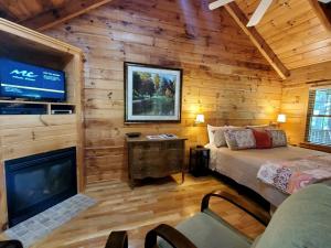 a bedroom with a bed and a fireplace in a log cabin at Peaceful Riverside Cabin Retreat Near New River, Virginia in Galax