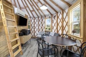 a living room with tables and chairs in a room at Secluded Off-Grid Yurt with Forest Views Near Trails in Sears, Michigan in Sears +19 photos