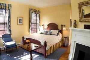 a bedroom with a bed and a chair and a fireplace at 1856 Manor Vacation Rental on Huge Horse and Cattle Farm near Charlottesville, Virginia in Gordonsville