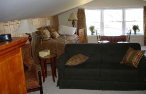 a living room with a couch and a bed at 1856 Manor Vacation Rental on Huge Horse and Cattle Farm near Charlottesville, Virginia in Gordonsville