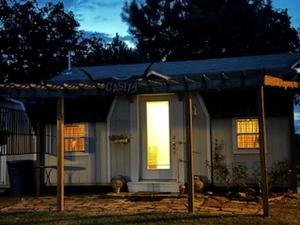 a small house with a light in the door at Comfy Equipped Lodge Great for a Peaceful Getaway in Texas in Waelder