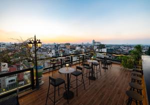 a balcony with tables and chairs and a view of a city at Hanoi Splendid Premium Hotel in Hanoi