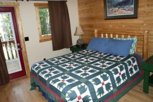 Ένα ή περισσότερα κρεβάτια σε δωμάτιο στο Cozy and Spacious Log Cabin Rental near Burt Lake State Park in Michigan
