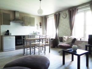 cocina y sala de estar con mesa y sillas en Les Petits Souliers, en Lestrem