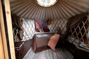 a room with a bed in a yurt at Nauti Otter Inn and Yurt Village in Bear Creek