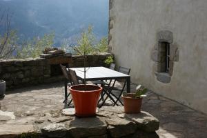 una mesa y sillas en un patio de piedra con vistas en Gîte Laboule pour 4 personnes, en Laboule