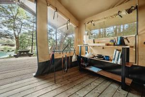 a room with a large window and a wooden deck at Outstanding Safari Tent with Fire Pit and Nice Sights in North Woodstock, New Hampshire in Woodstock
