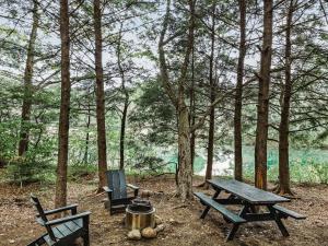 a picnic table and two chairs in the woods at Outstanding Safari Tent with Fire Pit and Nice Sights in North Woodstock, New Hampshire in Woodstock