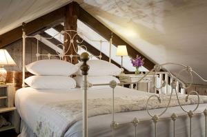 a bedroom with a bed with white sheets and pillows at Romantic Country Getaway with Wood-Burning Fireplace near Houston, Texas in Cat Spring