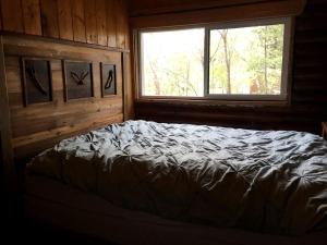 a bedroom with a bed and a window in a cabin at Traditional Log Cabin Rental near the Grand Tetons in Alpine, Wyoming in Alpine