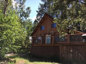 a large wooden house with a fence and trees at Traditional Log Cabin Rental near the Grand Tetons in Alpine, Wyoming in Alpine +5 photos