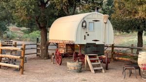 ein alter Anhänger steht neben einem Zaun in der Unterkunft Shepherds Camp Wagon Near Capitol Reef National Park in Grover