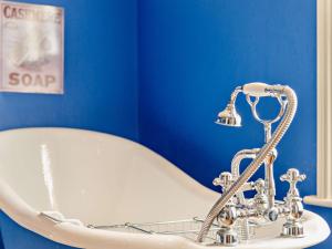a bath tub in a blue bathroom with a claw foot bathtub at 3 Bed in Gillingham 53854 in Gillingham +11 photos
