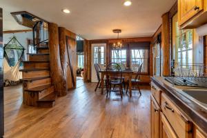 a kitchen and dining room with a wooden floor and a table at Secluded Delight: Unplug and Reconnect in a Special House in Lake Toxaway's Woods in Indian Lake Estates +40 photos