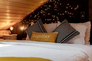 a bedroom with a bed with pillows and lights at Secluded Delight: Unplug and Reconnect in a Special House in Lake Toxaway's Woods in Indian Lake Estates