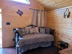 a room with a bed in a log cabin at Lovely Nature Getaways near Austin, Texas, in this Cute Cabin Rental in Pipe Creek in Pipe Creek