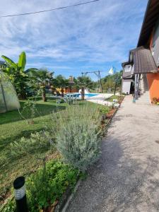 a garden with a pool and a resort at Sobe Kod Ćobe in Matuzići