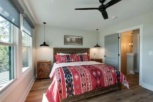 a bedroom with a red bed and a ceiling fan at Gorgeous Cabin Great for Groups or Families with Jacuzzi, Fire Pit and Views in Alabama in Grant