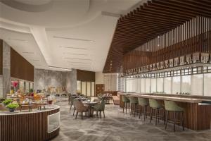 a restaurant with tables and chairs and a bar at Radisson Hotel Delhi MG Road in New Delhi