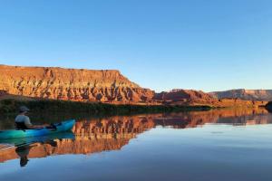 ein Mann in einem Kajak auf einem Fluss in einer Schlucht in der Unterkunft Dreamy Cave for Adventure Lovers with Incredible Night Sky Views and Close to Awesome Outdoor Activities in Moab, utah in Allen Memorial Hospital Heliport