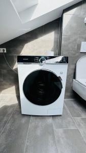 a washing machine sitting on the floor in a room at Charming Attic Retreat with Sloped Roof in Böblingen