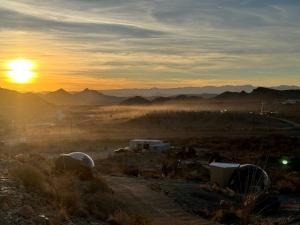 a sunset in the desert with the sun rising over mountains at Unique and Pet Friendly Glamping Dome with Views of Big Bend National Park, Perfect for a Texas Glamping Getaway in Terlingua