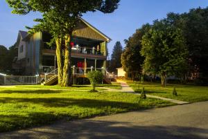 ein Haus auf einem Rasen mit einem Baum davor in der Unterkunft Waterfront Vacation Rental for Two Guests near Ohiopyle State Park, Pennsylvania in Confluence