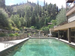 a swimming pool in front of a house at Amazing Mountainside Vacation Rental with Private Hot Springs in Hamilton, Montana in Darby