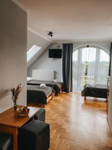 a living room with two beds and a table at Zajazd Czorsztyński in Maniowy