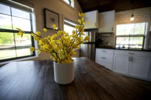 Sunset HarborにあるAmazing Cozy Cabin with Fireplace in Marion, Illinoisの木製テーブルに座る黄色い花瓶