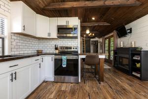 Sunset HarborにあるAmazing Cozy Cabin with Fireplace in Marion, Illinoisのキッチン(白いキャビネット、黒の電化製品付)