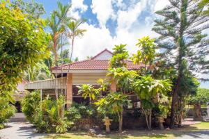 a house with palm trees in front of it at Villa with private pool and mountain views in Ban Khlong Son
