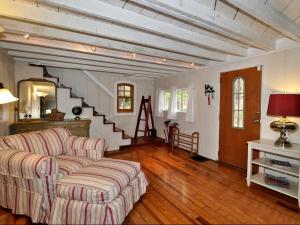 Una sala de estar con un sofá y una escalera. en Idyllic Getaway Cottage in the Woods near Woodstock, New York, en Woodstock
