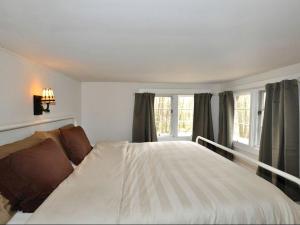 Un dormitorio con una gran cama blanca y ventanas. en Idyllic Getaway Cottage in the Woods near Woodstock, New York, en Woodstock 6 fotos más