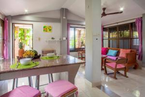 a kitchen and living room with pink chairs and a table at House 4 people sea view 100 m from the beach in Klong Muang Beach +66 photos