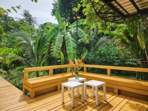 a wooden bench on a deck with a table and two stools at Pool Villa Suchada 3 bedrooms max 7 peoples in Ban Khlong Haeng