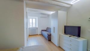 een woonkamer met een blauwe bank en een tv bij Casa Vacanze - Il Gelso in Collevecchio