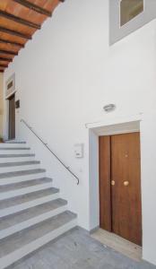 een trap in een wit gebouw met een houten deur bij Casa Vacanze - Il Gelso in Collevecchio