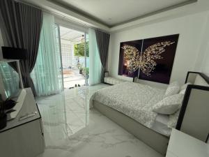 a bedroom with a bed with a butterfly painting on the wall at Baan Suan pool valley Villa in Ban Nong Thale +69 photos