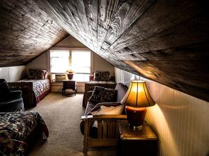 a attic room with a bed and a table with a lamp at Charming Glamping Rental with Fireplace near Great Smoky Mountains National Park in Greeneville