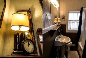 a bathroom with a clock and a mirror and a sink at Charming Glamping Rental with Fireplace near Great Smoky Mountains National Park in Greeneville +31 photos