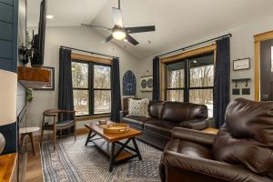 a living room with a leather couch and a table at Lakefront Cabin with Fire Pit in Carbondale, Illinois in Makanda