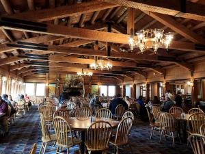 a dining room with tables and chairs with people sitting at them at Lakefront Cabin with Fire Pit in Carbondale, Illinois in Makanda
